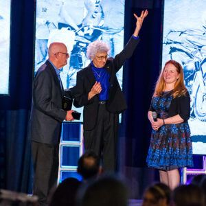 Mary McGee (middle) accepting her Hall of Fame ring from AMA Motorcycle Hall of Famer Brian Slark (left) and AMA Board of Directors Chair Maggie McNally-Bradshaw.