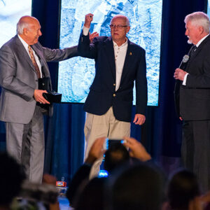 AMA Motorcycle Hall of Fame inductee Clifford “Corky” Keener (middle) accepting his hall of fame ring from AMA Motorcycle Hall of Famer Peter Starr (left) and American Motorcycle Heritage Foundation Chairman Ken Ford.